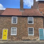 An image of 2 homes with brightly coloured doors