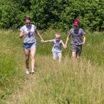 Photo-of-a-young-woman-walking-through-rough-meadow-grass-with-two-young-boys-for-web