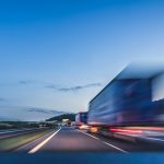 Background photograph of a highway. Truck on a motorway, motion