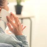 Woman talking by mobile phone at home